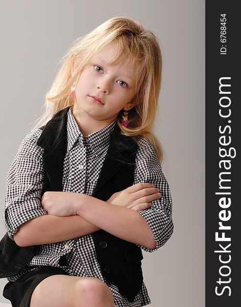 Cute little blond girl poses with serious expression