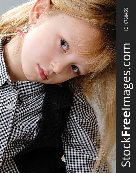 Cute little blond girl poses with serious expression