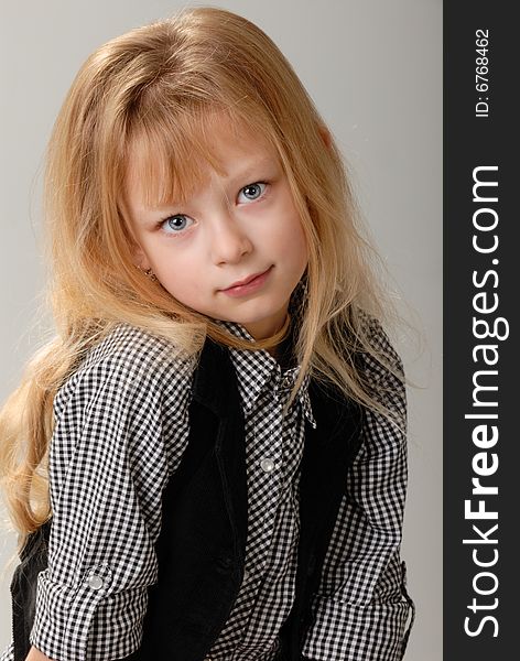 Cute little blond girl poses with serious expression