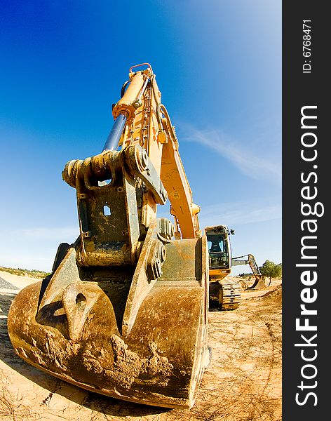 Yellow excavator in a sunny day