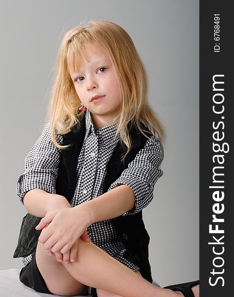 Cute little blond girl poses with serious expression