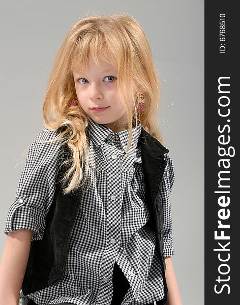 Cute little blond girl poses with serious expression