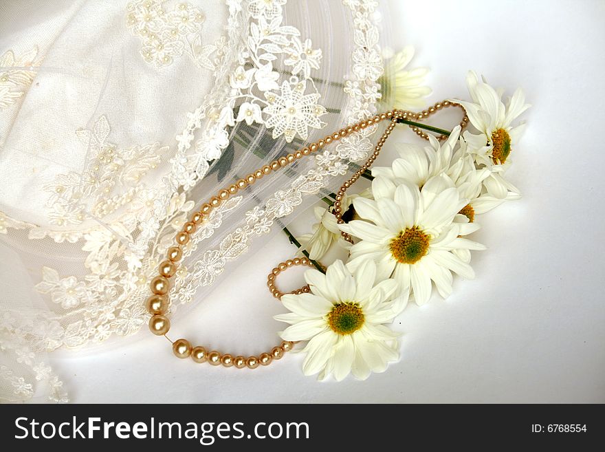 Pearl necklace and daisies on lace hat