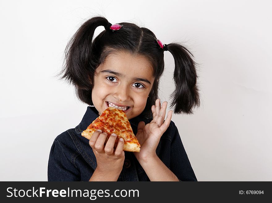 Girl eating pizza slice and smiling