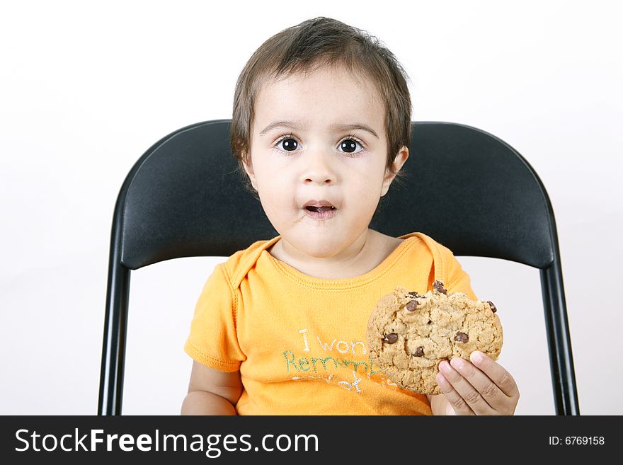 Small girl eating chocolate chip cookie. Small girl eating chocolate chip cookie