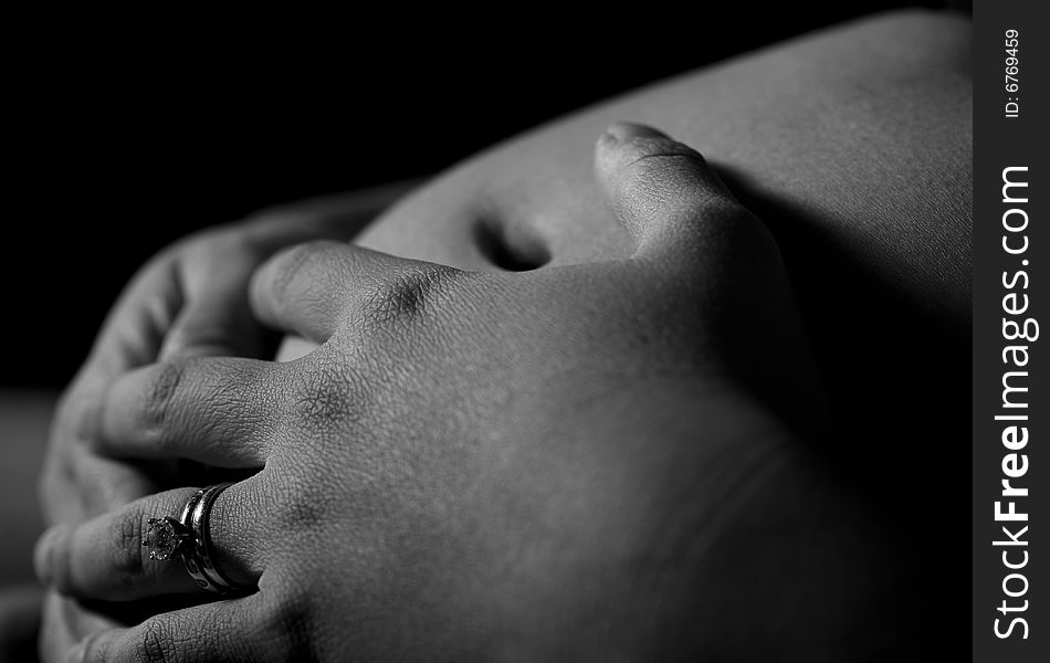 Pregnant woman holding her belly with both hands with view of wedding ring. Pregnant woman holding her belly with both hands with view of wedding ring