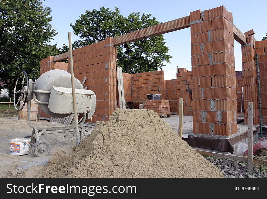 A brick layer putting down another row of bricks. A brick layer putting down another row of bricks