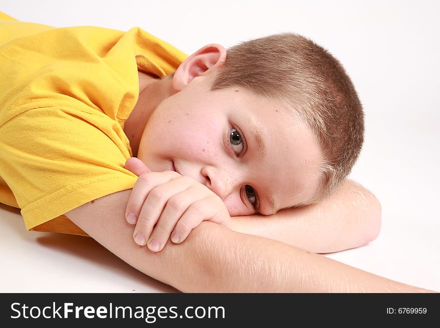 Young boy is lying on the white background. Young boy is lying on the white background.