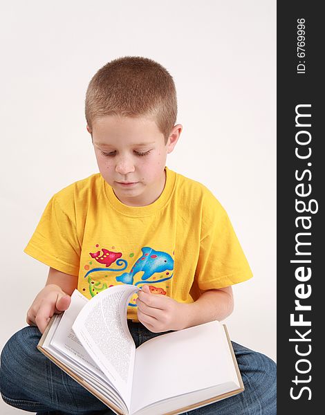 Young boy is reading the book - on white background. Young boy is reading the book - on white background