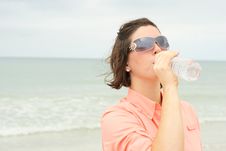 Beautiful Brunette Drinking Water At The Beach Royalty Free Stock Photos