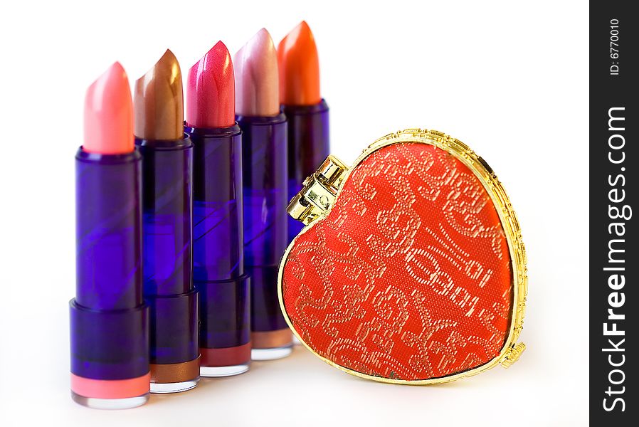 Five varicolored lipsticks and heart shaped mirror. Five varicolored lipsticks and heart shaped mirror
