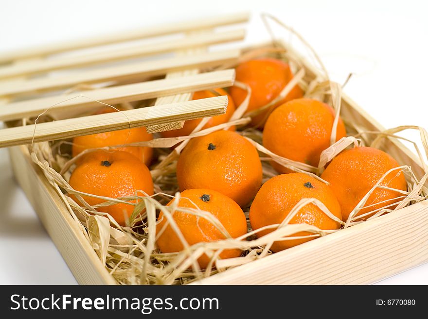 Tangerines with straw in wooden box