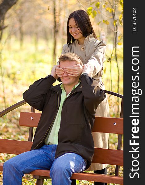 Young happy girl has closed its eyes a young man.  Focus point on girl face. Young happy girl has closed its eyes a young man.  Focus point on girl face