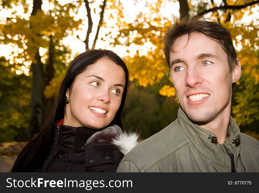 Happy couple in the evening park (girl in focus)