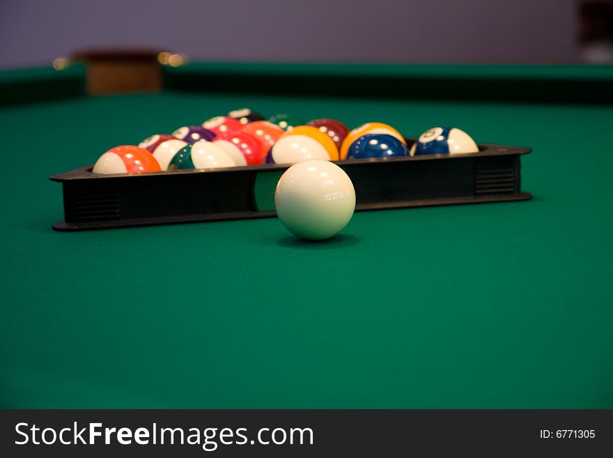 Color billiard balls on a green table in sport bar