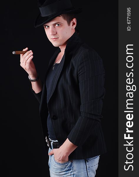 Portrait of young gangster in black suit with cigar. Portrait of young gangster in black suit with cigar