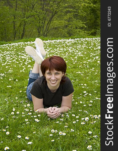 The young woman lays on a grass in park