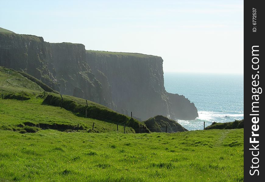 Green grass climbs the cliffs of Moher in County Clare Ireland. Green grass climbs the cliffs of Moher in County Clare Ireland.