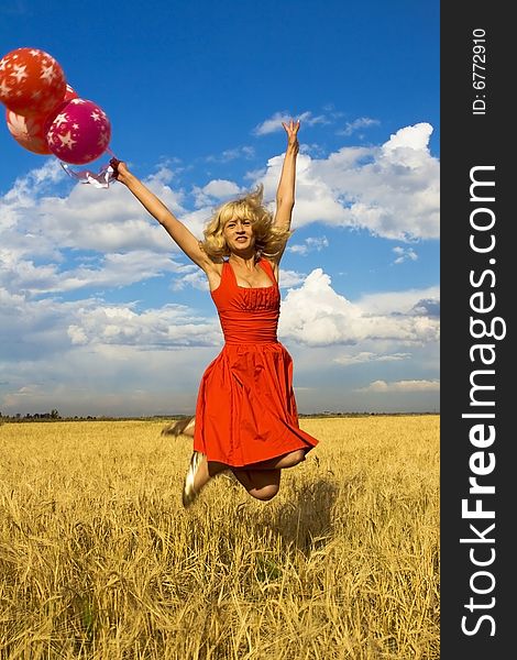 Lady in red jumping with balloons. Lady in red jumping with balloons