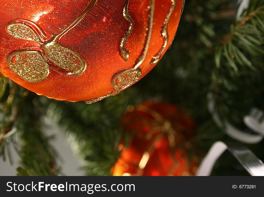 Gold Christmas ball and  paper streamer hanging from pine tree