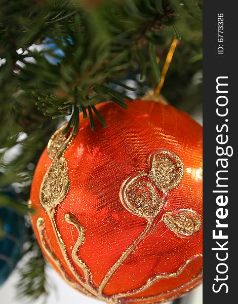 Gold Christmas ball and  paper streamer hanging from pine tree