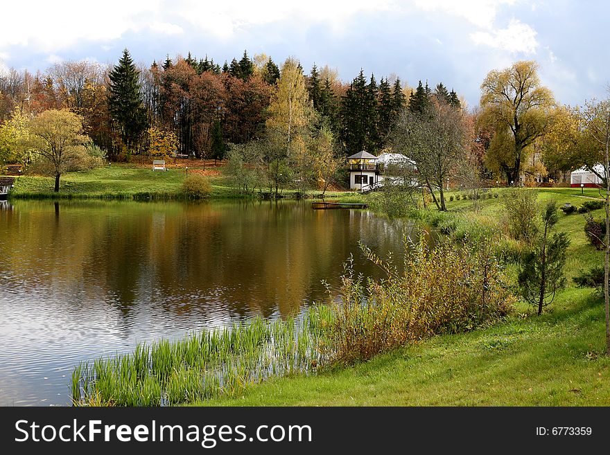 Beautiful lake with bridge in the autumn park