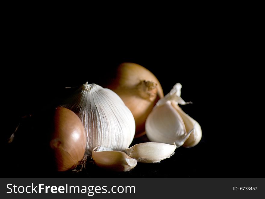 Onions and garlics set in a dark background which is used in many foods. Onions and garlics set in a dark background which is used in many foods.