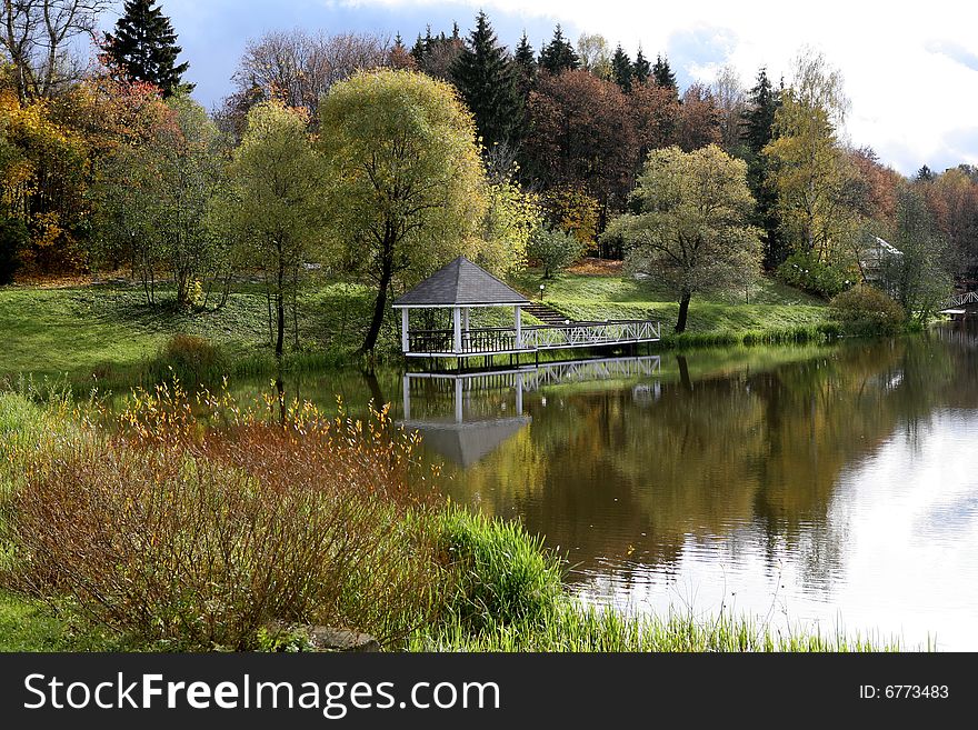 Beautiful lake with bridge in the autumn park