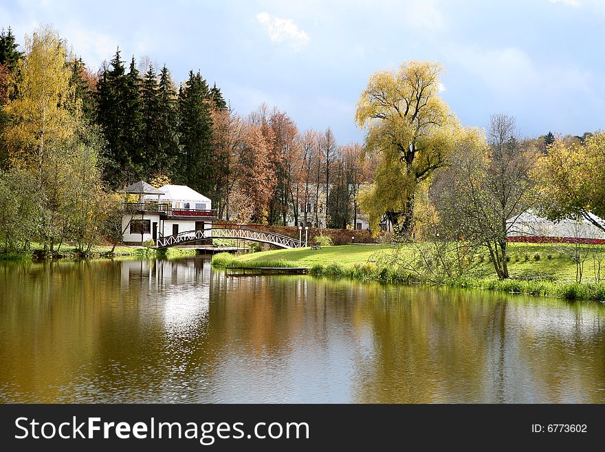 Beautiful lake with bridge in the autumn park