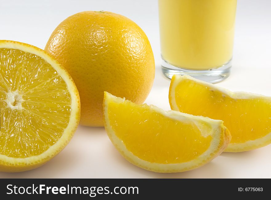 Ripe sliced oranges with a glass filled with juice. Ripe sliced oranges with a glass filled with juice