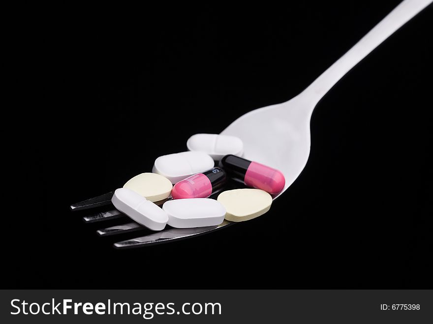 A close-up of pills on a fork