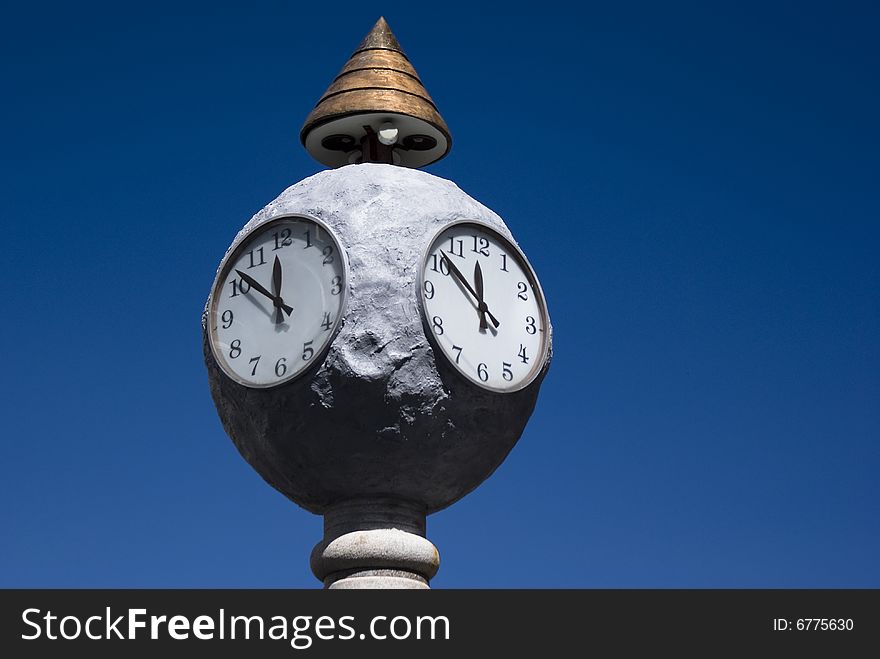 White clocks in square, blue sky. White clocks in square, blue sky