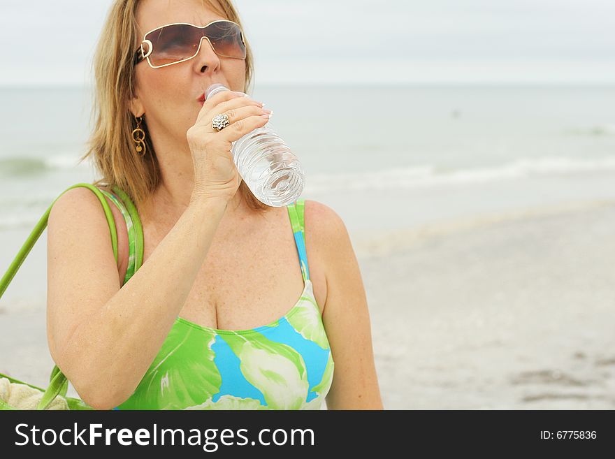 Woman Drinking Water At The Beach
