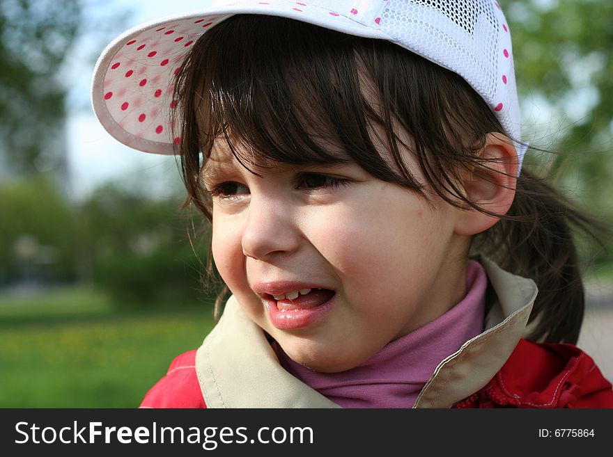 Offended and crying little girl in the park