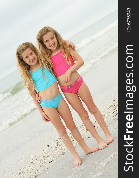 Twin sisters at the beach vertical angle