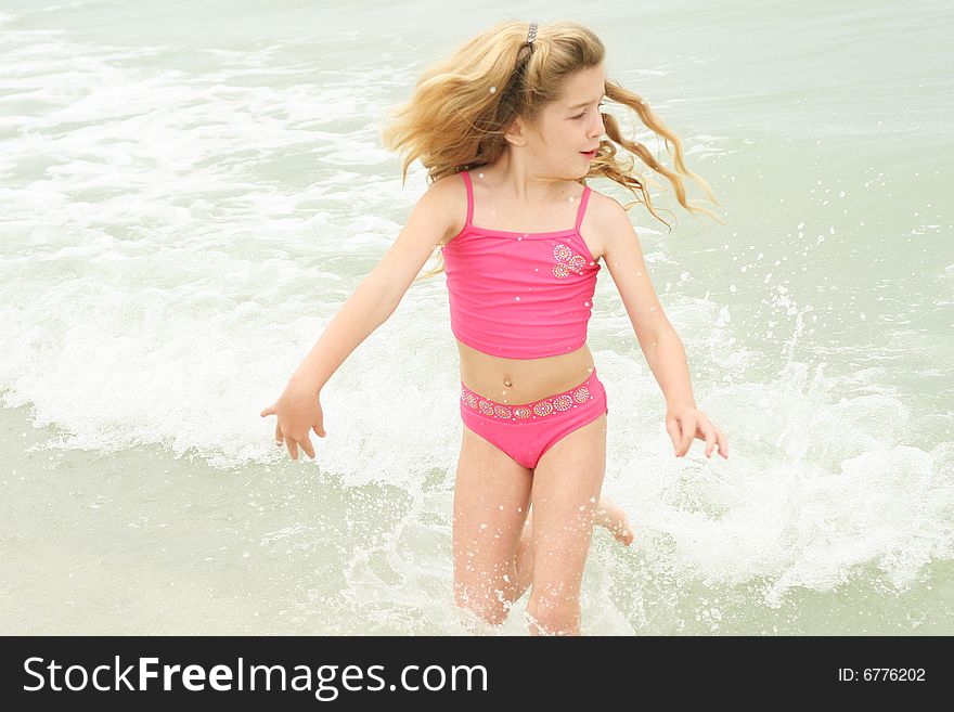 Shot of a little girl running from the waves