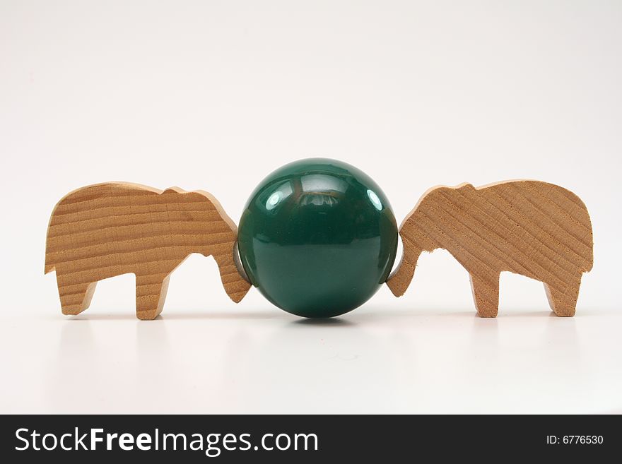Wooden toys elephants push the ball on white