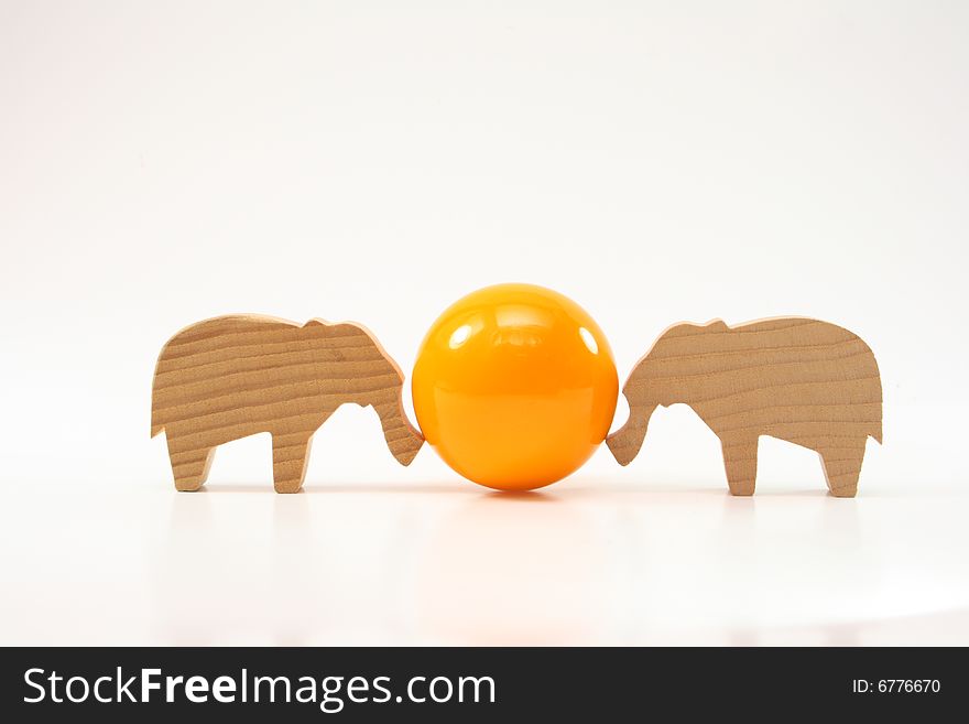 Wooden toys elephants push the ball on white