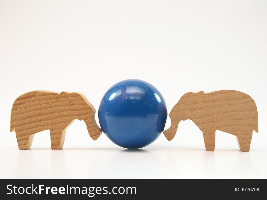 Wooden toys elephants push the ball on white