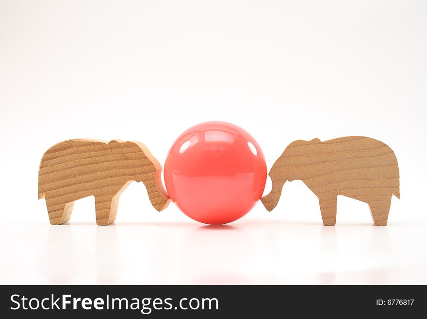 Wooden toys elephants push the ball on white