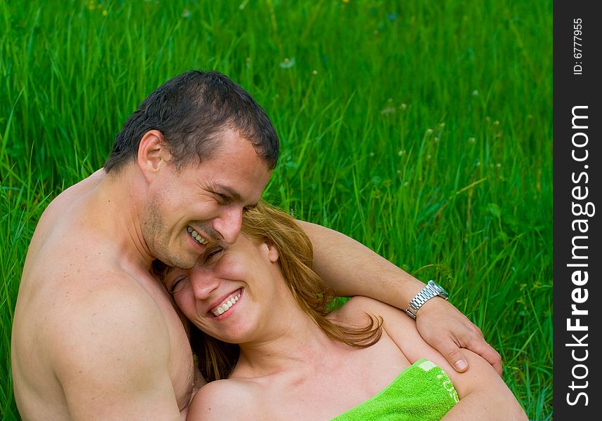 Young loving couple laughing in grass. Young loving couple laughing in grass