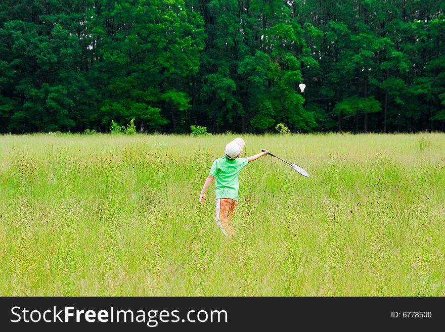 Cute kid playing badminton outdoors