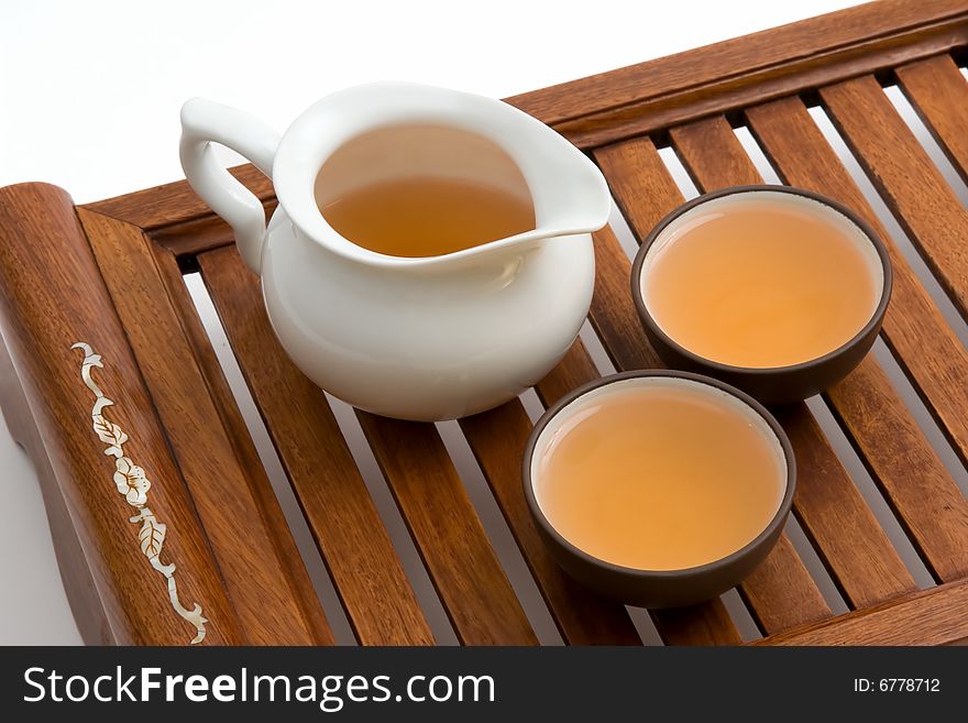 A tray for chinese tea ceremony with cups of tea and teapot isolated on white background. A tray for chinese tea ceremony with cups of tea and teapot isolated on white background