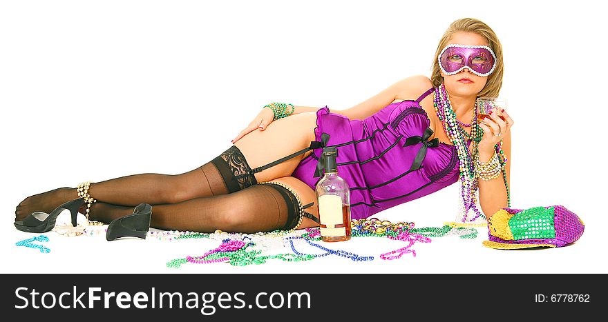 Young and beautiful caucasian in colorful mardi gras dress wearing a lot of beads laying on the floor with whisky bottle. Young and beautiful caucasian in colorful mardi gras dress wearing a lot of beads laying on the floor with whisky bottle