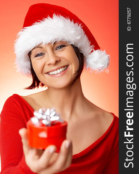 Beautiful woman holding christmas gift on red background. Beautiful woman holding christmas gift on red background