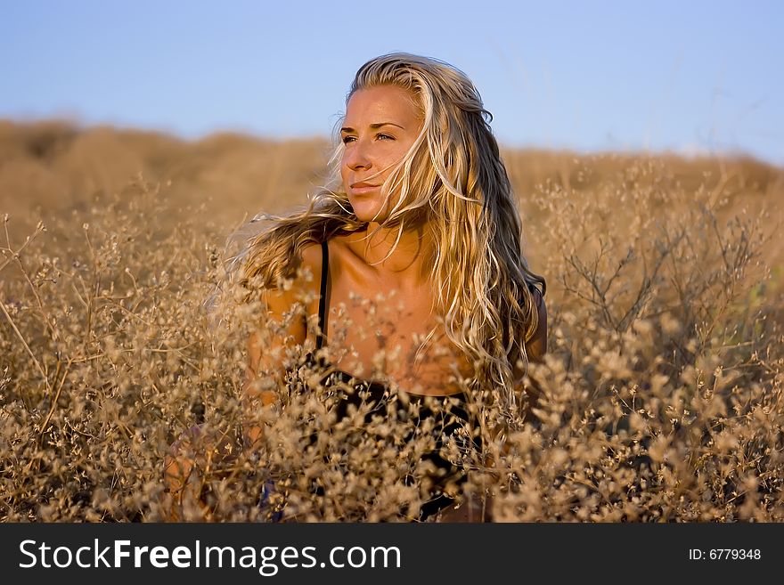 Girl sitting on straw grass in the valley. Girl sitting on straw grass in the valley