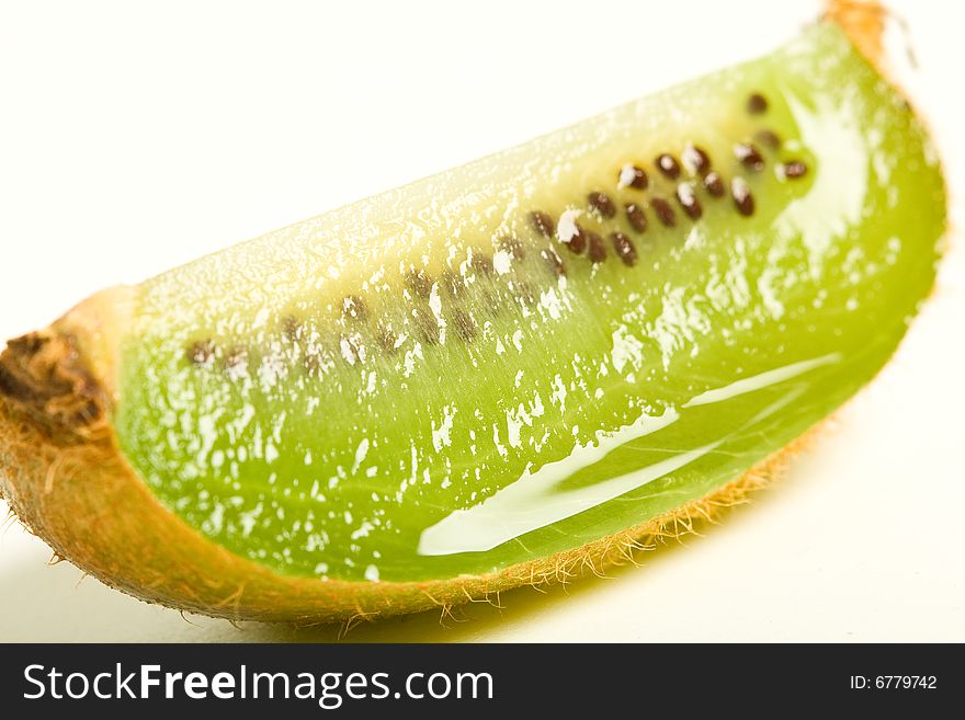 A single juicy kiwi quarter isolated against a white background. A single juicy kiwi quarter isolated against a white background.