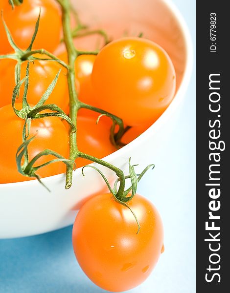 Fresh Yellow Cherry tomatoes with vine in porcelain bowl. Fresh Yellow Cherry tomatoes with vine in porcelain bowl.