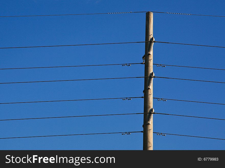 Power lines and pole against a pure blue sky.