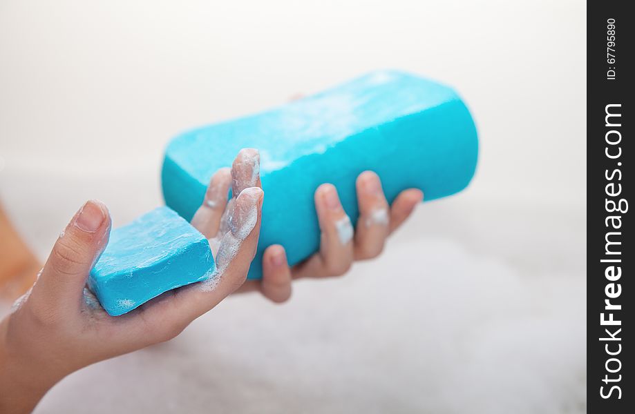 Girl holding blue soap and sponge. hands closeup. Girl holding blue soap and sponge. hands closeup